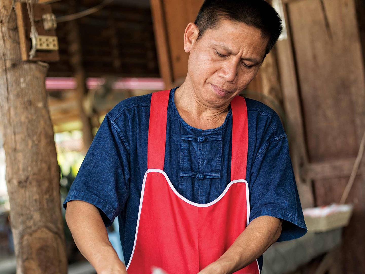 Man wearing red apron and indigo blue shirt